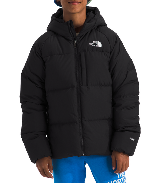 Person wearing a black puffer jacket and blue pants with a colorful beanie on a white background