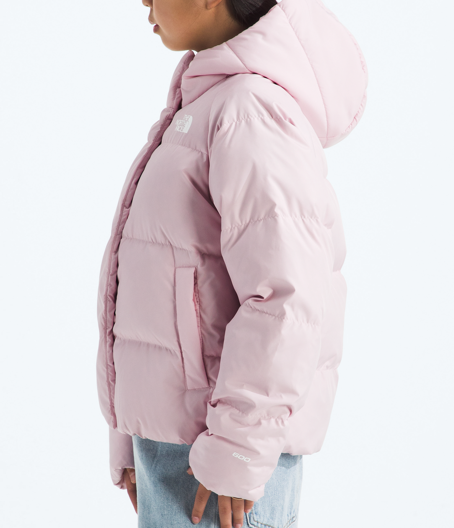 Person wearing a pink puffer jacket and red beanie on a white background