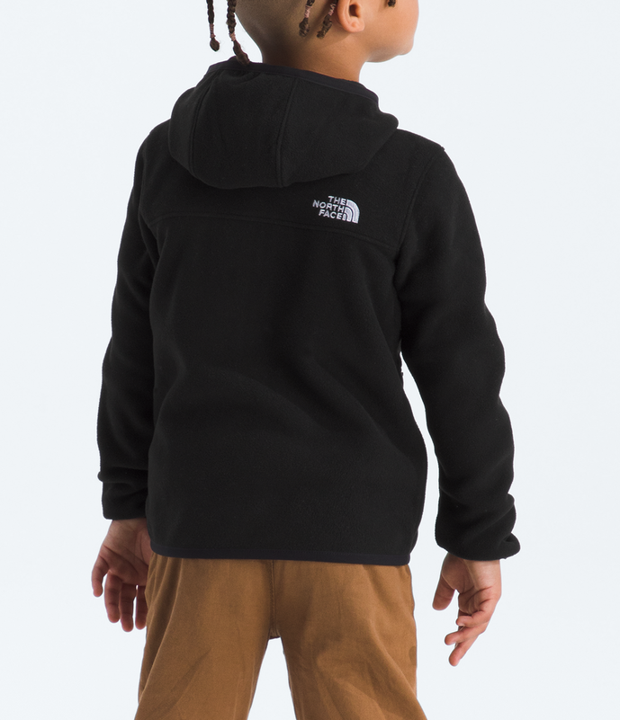 Child wearing a black hoodie with a logo and brown pants on a white background