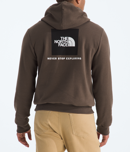Person wearing a brown hoodie with The North Face logo on the back, standing against a white background.