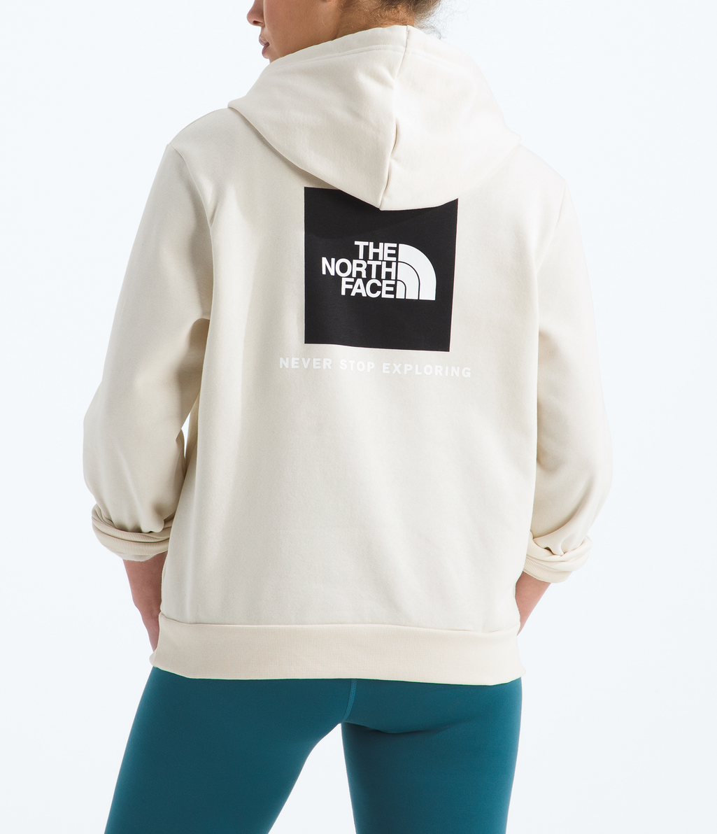 Person wearing a beige The North Face hoodie with logo on a white background