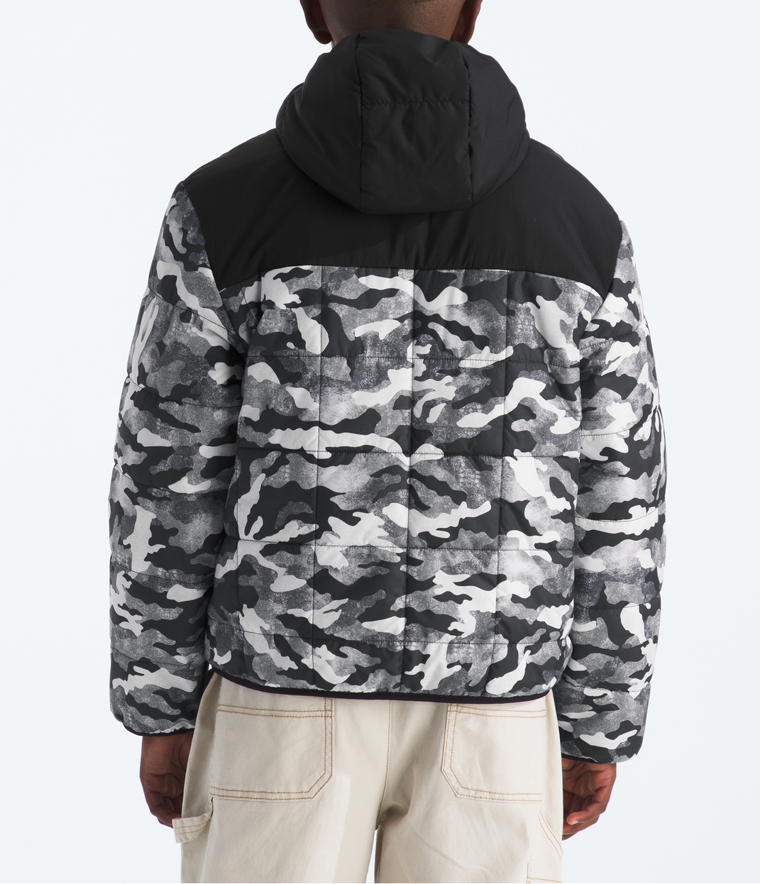 Person wearing a black and gray camouflage jacket on a white background