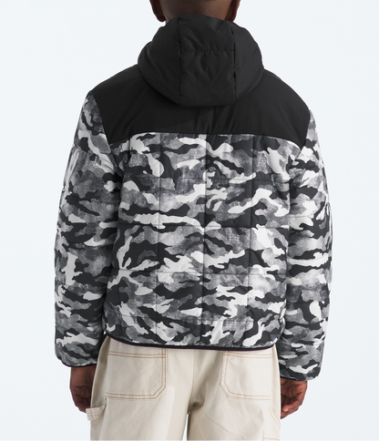 Person wearing a black and gray camouflage jacket on a white background