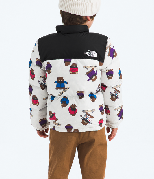Child wearing a patterned jacket with The North Face logo on a white background