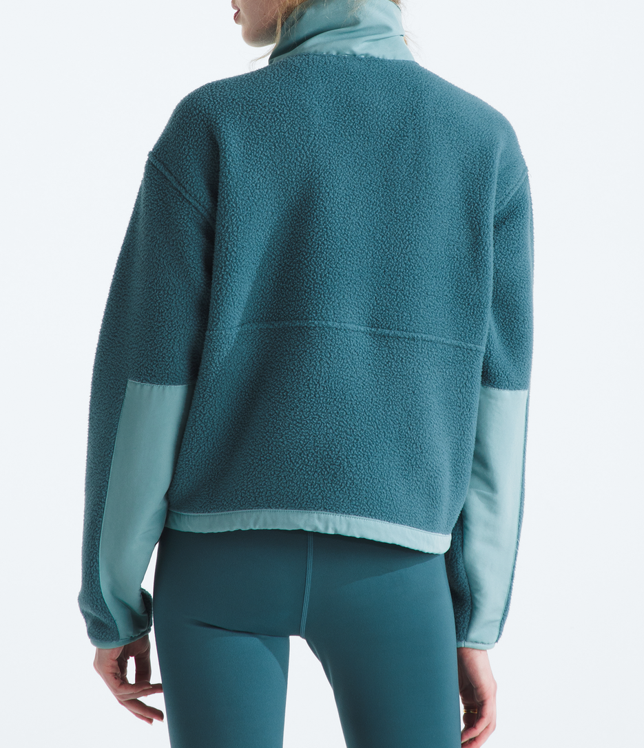 Person wearing a teal fleece jacket and pants with a matching beanie on a white background