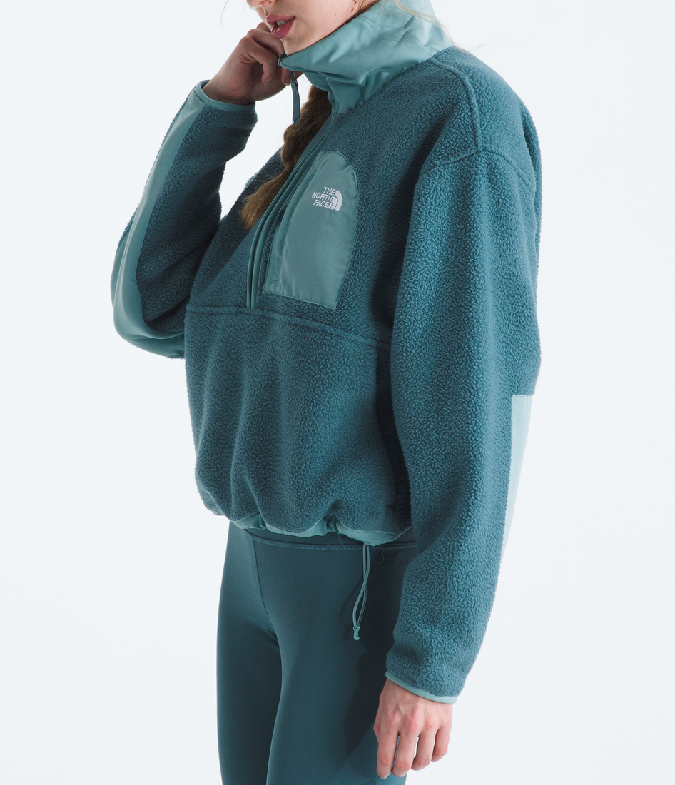 Person wearing a teal fleece outfit with a matching beanie on a white background