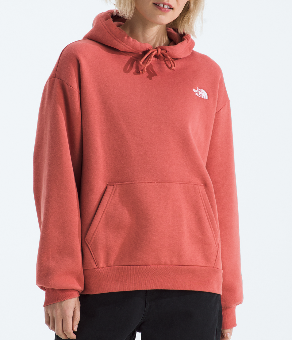Person wearing a pink hoodie with a logo on a white background