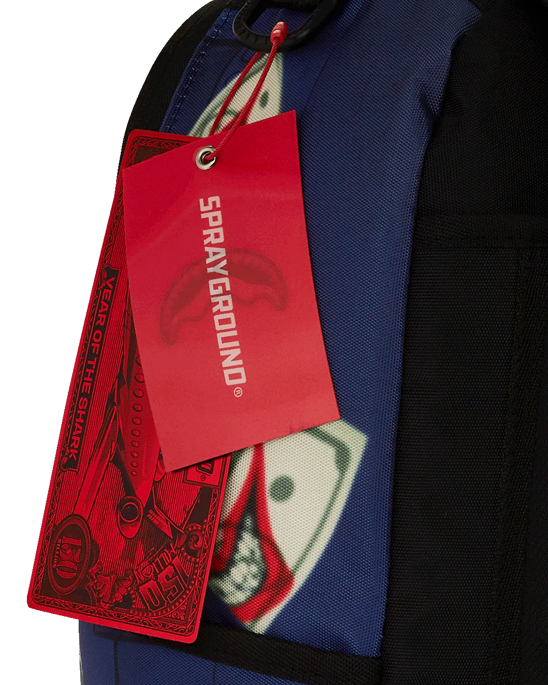 Red 'Sprayground' tag attached to a blue jacket with a graphic design.
