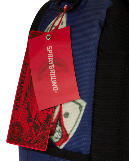 Red 'Sprayground' tag attached to a blue jacket with a graphic design.
