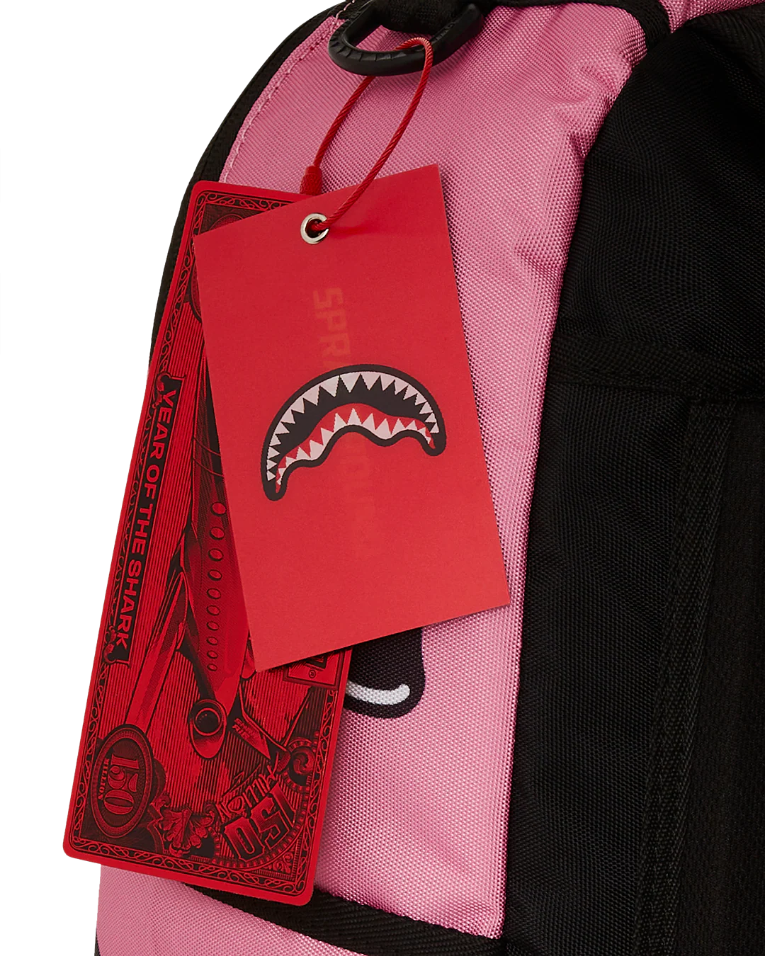 Red tag with a shark design on a pink and black bag