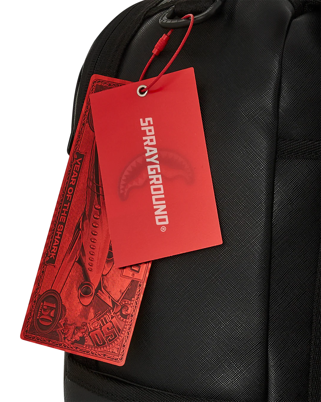Black backpack with red 'Sprayground' tags attached