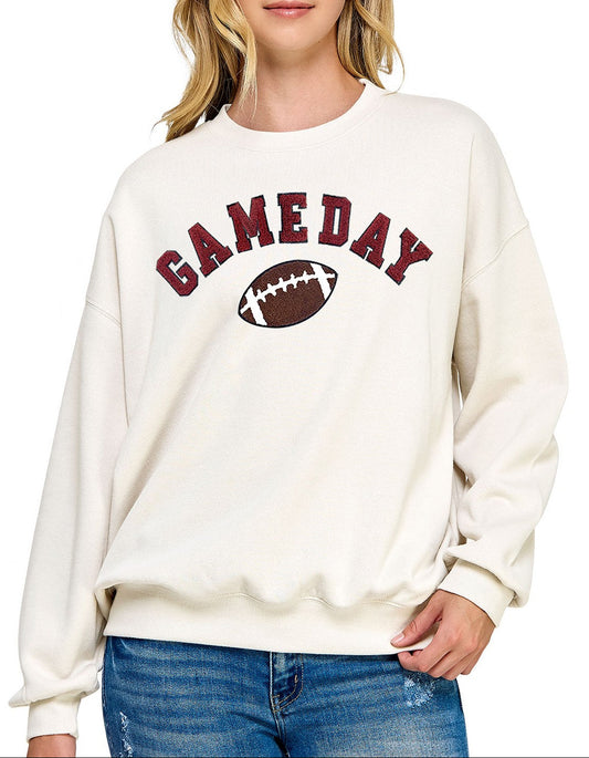 Woman wearing a white sweatshirt with 'GAMEDAY' and a football graphic on a white background