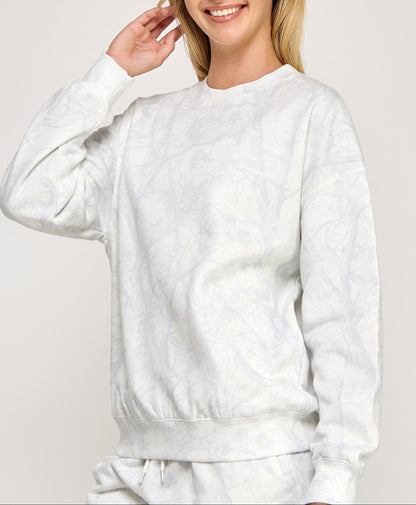 Person wearing a white sweatshirt on a plain background